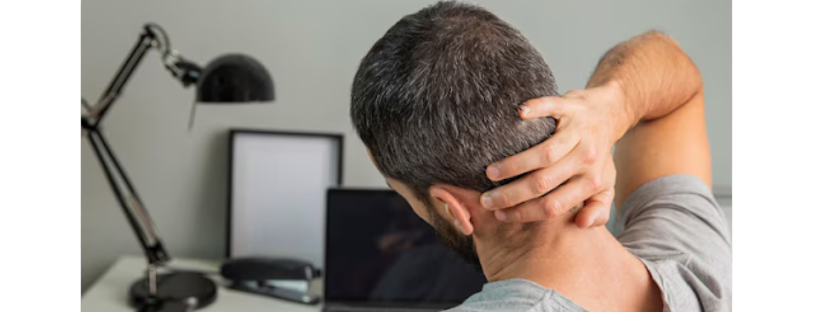 man experiencing neck pain in the workplace