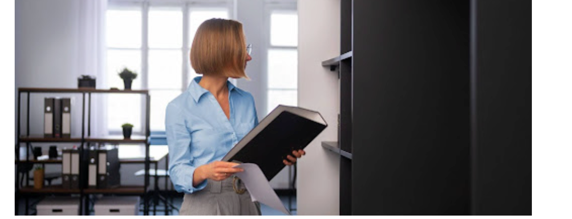 woman in an office setting interacting with a storage cabinet or filing cabinet