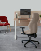 300 series orthopaedica Torasen chair. The chair is at a desk in a office setup. The chair has an extra high back, fully upholstered with black features.