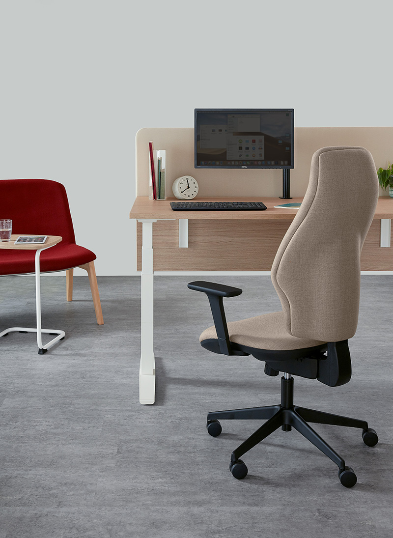 300 series orthopaedica Torasen chair. The chair is at a desk in a office setup. The chair has an extra high back, fully upholstered with black features.